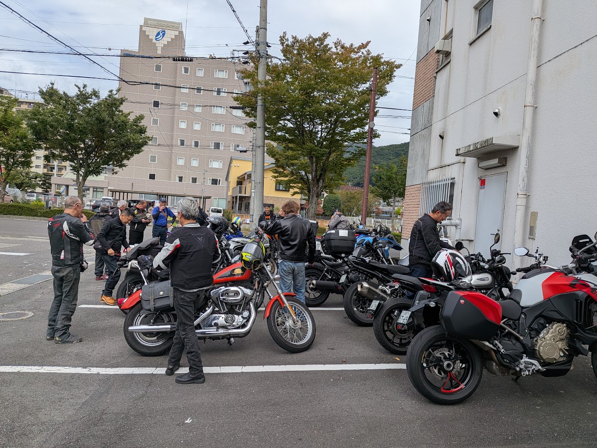 諏訪の集合場所の駐車場。バイクが並び、メンバーが支度をしている